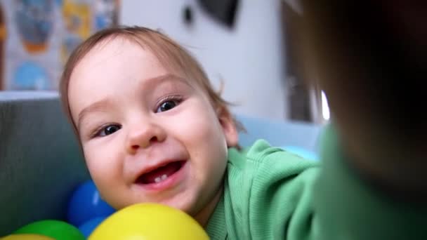 관심과 미소로 카메라를 만지는 아름다운 행복한 귀여운 아기는 분지에 흥분하게 — 비디오