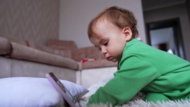 Sevimli Bir Erkek Bebek Önünde Duran Telefonun Üzerine Eğilmiş Odaklanmış — Stok video