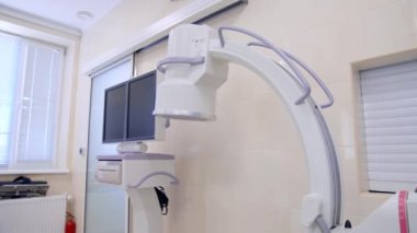 C-Arm floroskopi makinesi modern ameliyathanede duruyor. Ciğer havalandırma sistemi olan operasyon masası yakında duruyor..