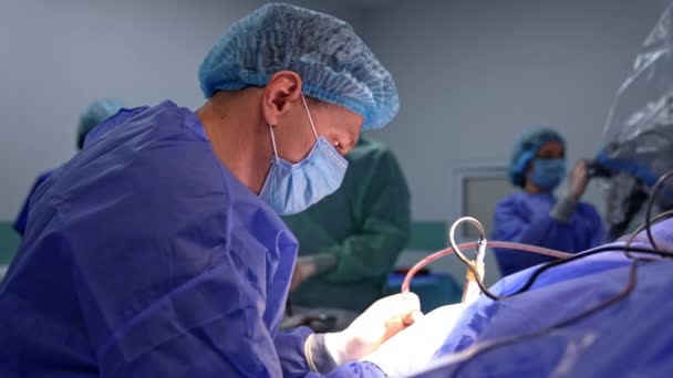 Manlig Kirurg Som Opererar Med Elektrisk Utrustning Medicinsk Täcka Mikroskop — Stockvideo