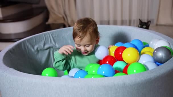 Счастливый Ребенок Сидит Мягкой Раковине Многочисленными Яйцами Мама Бросает Игрушки — стоковое видео