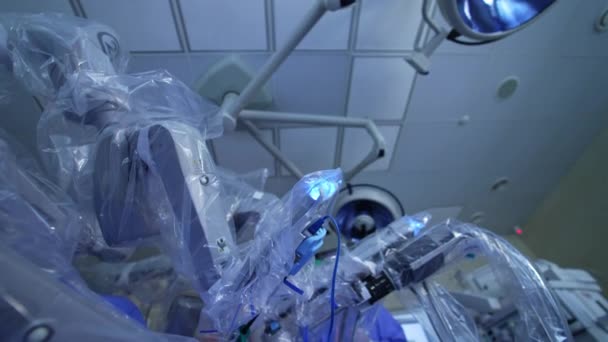 外科ロボットの手術現場に立っている女性医師 手術のプロセスをスクリーンで見ている医療専門家 ローアングルビュー — ストック動画