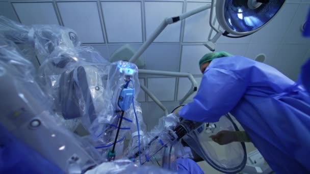 女性医師がロボットの装置にやってきます マニピュレーターアクティブアームにフィッティングする医学スクリーン ローアングルビュー — ストック動画