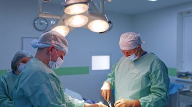 Genç ve yaşlı doktor estetik cerrahide birlikte çalışıyor. Modern aletleri ve aletleri uygulayan cerrahlar. Arka planda bayan hemşire.