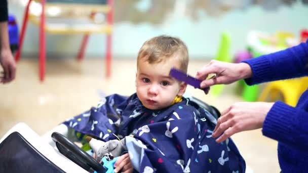 Barberaren Kammar Småbarnsfrisyr Och Plockar Tråden Vackert Kaukasiskt Barn Som — Stockvideo