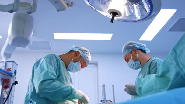 수술실에서 일하는 의사의 램프의 가동을 실행하는 직업적인 플라스틱 외과의사 — 비디오