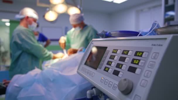 現代の装置は手術中に切り替え 作業しました バックドロップで手術を行う医師のチーム — ストック動画