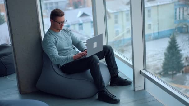 Młody Człowiek Siedzący Wygodnie Fotelu Fasolą Pracujący Nad Laptopem Zajęty — Wideo stockowe