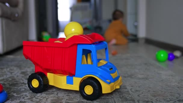 Ljus Leksakslastbil Fylld Med Plastbollar Liten Unge Orange Kostym Kryper — Stockvideo