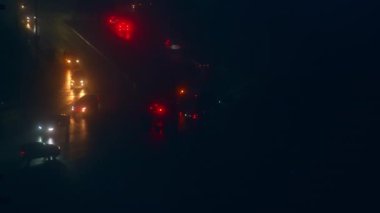 Arabalar yavaşça ilerlerken çift yönlü yol. Kesinti anında araçların sadece farları olan karanlık bir cadde..