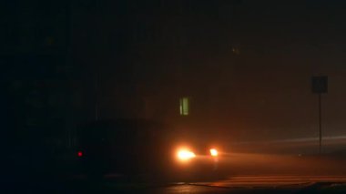 Otoyolun yakınındaki çok katlı binanın pencerelerinden birinde loş ışık var. Ukrayna şehrinin karanlık yollarından geçen karartma zamanı.