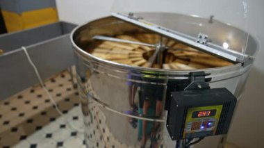 İçinde dönen çerçeveler olan elektronik makine. Arı kovanında bal toplama ekipmanı..