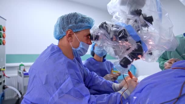 Чоловічий Нейрохірург Дивиться Мікроскоп Застосовує Інструменти Які Він Тримає Обох — стокове відео