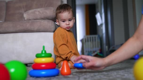 Ręka Mamy Odłącza Części Piramidy Zabawek Mały Syn Bacznie Obserwuje — Wideo stockowe