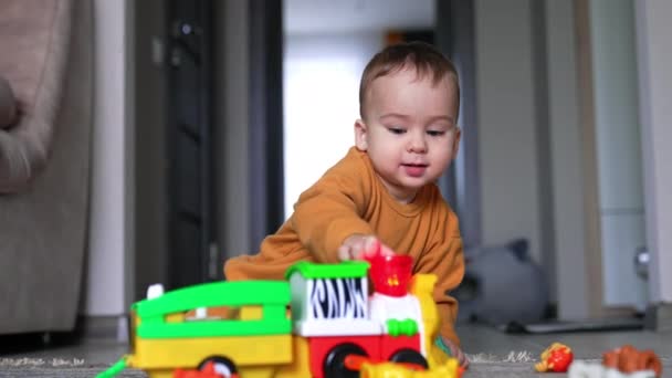 Entzückendes Kaukasisches Kind Sitzt Auf Dem Boden Und Spielt Mit — Stockvideo