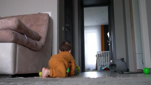 一个赤脚的小孩在房间的地板上玩球 可爱的孩子甜甜地追着玩具笑 — 图库视频影像