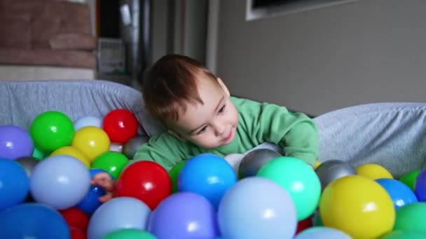 Грайливий Кавказький Хлопчик Стукає Яскраві Кульки Сухого Басейну Маленька Дитина — стокове відео