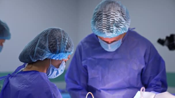 Uniformovaní Lékaři Sklonili Hlavy Soustředili Operaci Elektrické Zařízení Používá Chirurg — Stock video