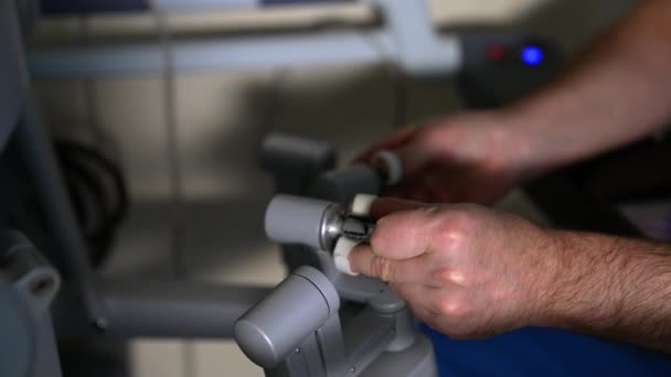 ロボット機器の動作モジュールに取り組む経験豊富な医師 プロのルール ダヴィンチ手術システムの腕 — ストック動画