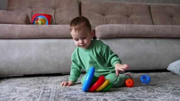 Mały Chłopczyk Siedzi Dywanie Bawiąc Się Zabawkową Piramidą Dzieciak Odwraca — Wideo stockowe