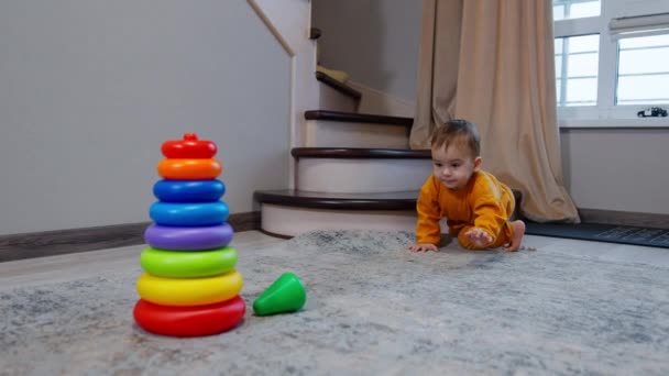 Dziecko Czołga Się Piramidy Zabawek Bierze Górę Dziecko Siedzi Kolanach — Wideo stockowe
