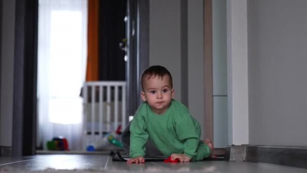 Schöne Baby Kriecht Den Raum Mit Einem Roten Spielzeug Der — Stockvideo