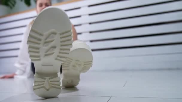 Yerde Oturmuş Gülümseyen Sarışın Kadın Ayakkabılarını Kameraya Yaklaştırıyor Stüdyoda Moda — Stok video