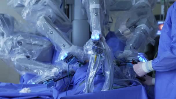 ヴィンチ ロボット外科医が手術をしています ラテックス手袋の認識されていない医師は 患者の体に長い楽器を保持します — ストック動画