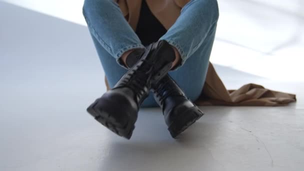 Vrouw Zit Vloer Haar Stijlvolle Zwarte Laarzen Naast Camera Sluit — Stockvideo