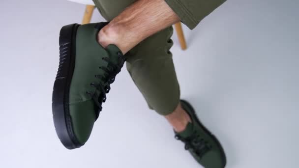 Человек Темно Зеленых Туфлях Черными Шнурками Подошвами Мужчина Сидит Стуле — стоковое видео