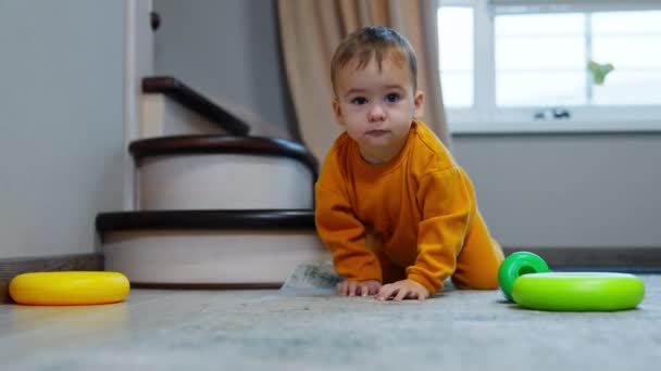 Roztomilý Chlapeček Oranžovém Sportovním Obleku Stojí Všech Čtyřech Podlaze Dívá — Stock video