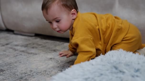 Bayi Laki Laki Mengenakan Setelan Oranye Merangkak Oleh Lantai Dalam — Stok Video