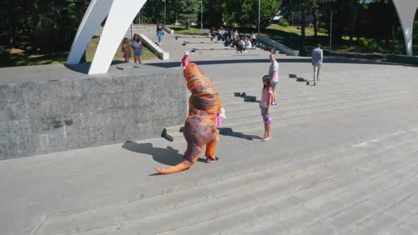 一个穿着迪诺吉祥物的有趣男人穿过街道 在街上散步的恐龙的迷人装束 — 图库视频影像