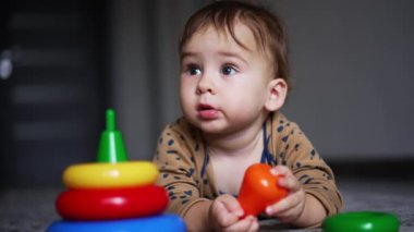 Oyuncaklarla eğitici bebek aktiviteleri. Küçük sevimli çocuk renkli oyuncaklarla oynuyor..