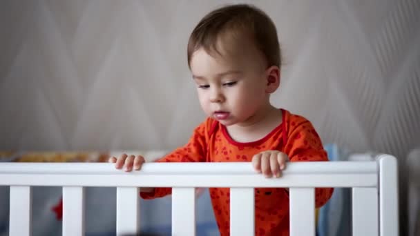ベッドの上に立っているかわいい子 ボーイと遊ぶ愛らしい新生児 — ストック動画