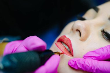 Güzellik salonu kozmetikçisi. Kozmetik dudak dövmesi yapma.