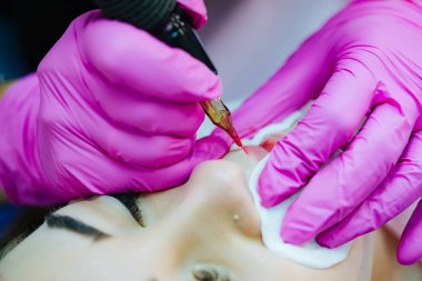 Güzel bayan makyajı uygulanıyor. Kalıcı kozmetoloji prosedürü.