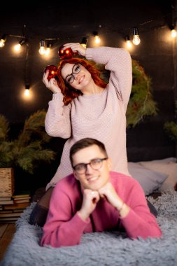 Genç çift Noel süslemeleriyle yatakta yatıyor..