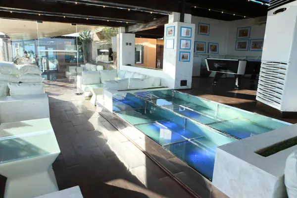 Swimming pool and white furniture in room.