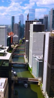 Chicago Nehri 'nde birden fazla köprü ve yelkenli yatlar var. Su yolundaki güzel binaların arasındaki drone görüntüleri. Dikey video.