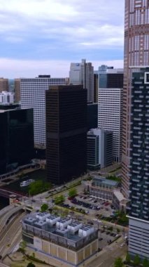 Şikago şehir merkezindeki binalar arasında akan dar bir nehir. Köprüden ve otobanlardan geçen ve otoparklarda bekleyen bir sürü araba var. Dikey video.