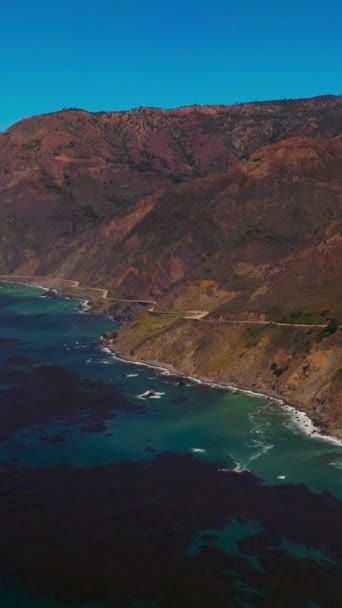 加利福尼亚海岸线上的岩石 美丽的深蓝色水带海藻在水面绽放 阳光照在鸟瞰上 垂直录像 — 图库视频影像