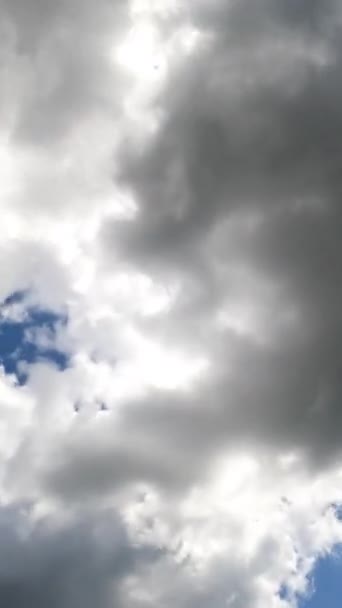 青空に形成される白と灰色の雲 雲を通り抜ける太陽の日差し 下からの眺めです バーティカルビデオ — ストック動画