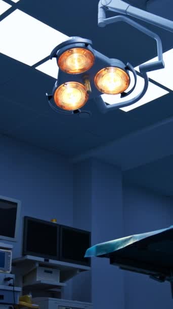 ライトがついた現代的なオペレーショナルルームの天井を眺める 手術用の黄色いライト回転ランプをより近くで見てください ローアングルビュー バーティカルビデオ — ストック動画