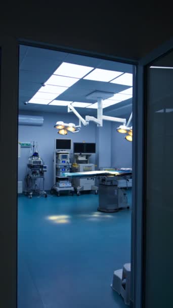 暗いホールから光と広々とした手術室に入ります ランプがついた操作テーブルが上にスイッチを入れました 壁の先進的な設備 バーティカルビデオ — ストック動画