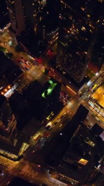Yoğun trafiği olan canlı bir New York. Geceleri inanılmaz metropolün aydınlık sokakları. Havadan bakış açısı. Dikey video.