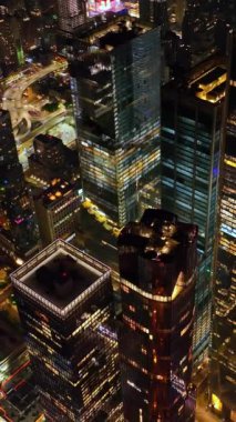 Geceleri muhteşem New York 'un göz kamaştırıcı manzarası. İnsansız hava aracı görüntüsü, canlı şehir ışıkla dolu. Dikey video.