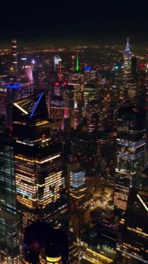 Geceleri nefes kesen New York manzarası. İnsansız hava aracı görüntüleri hiç uyumayan metropolün sonsuz panoramasında. Dikey video.