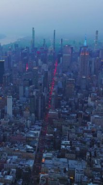 Gelecek akşam New York 'un büyüleyici bir manzarası var. Alacakaranlıkta metropolü kaplayan mavi sis. Hava görüntüsü. Dikey video.