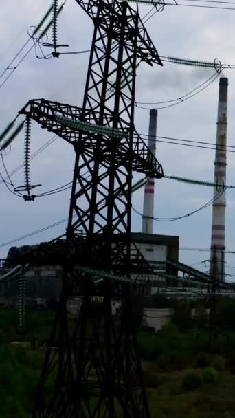 工厂背景的电塔 高压电梯形靠近有害企业 自然和技术的概念 摄像头升起了 垂直录像 — 图库视频影像